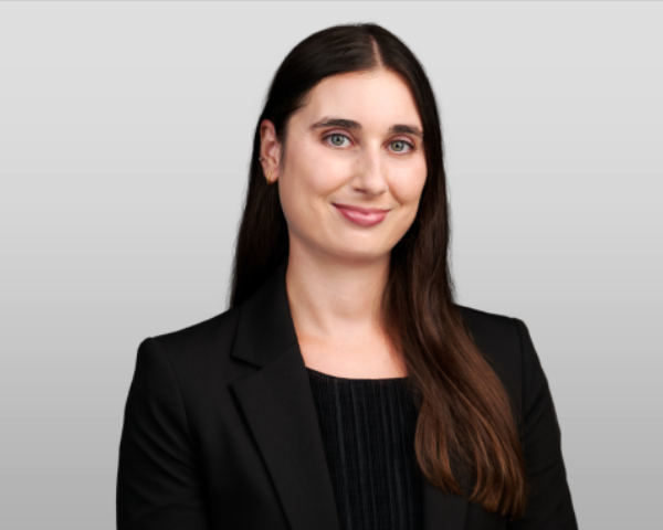 Photo of Sarah Zhukovsky, a smiling woman in a dark suit.