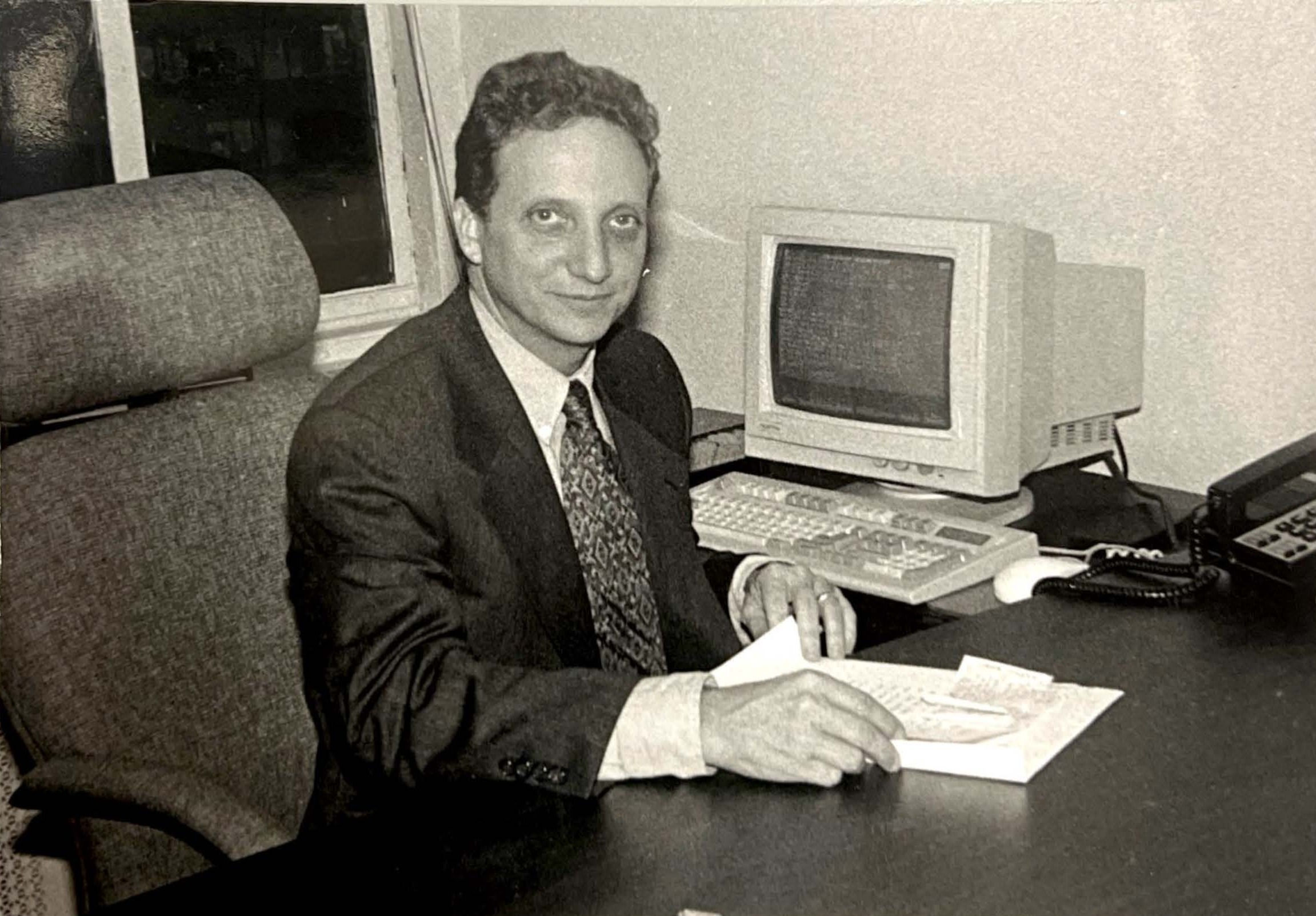 A black and white photo of Michael lent sitting at his desk at the New York office of Progressive Asset Management